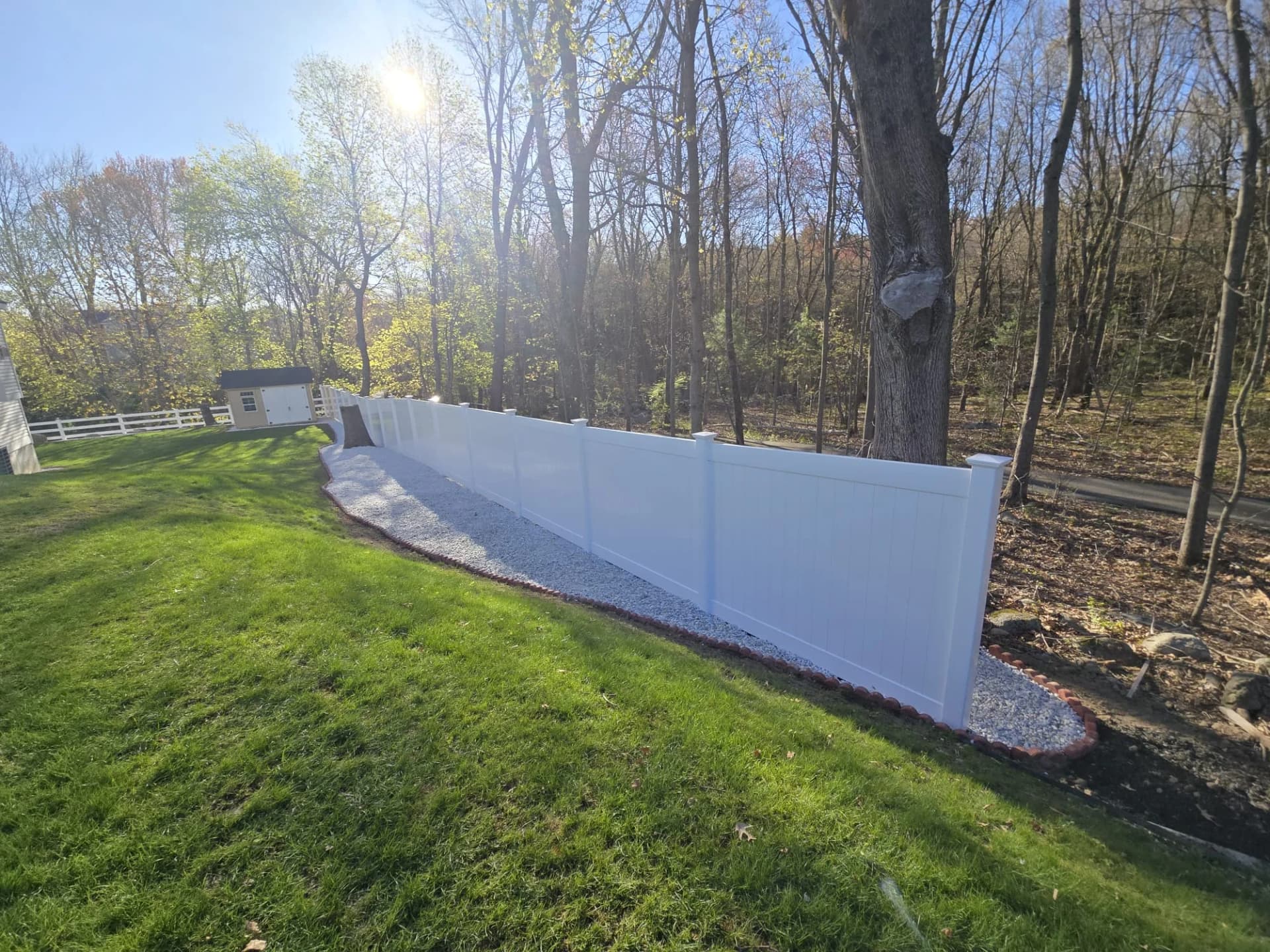Cerca branca de privacidade ao longo da borda de um jardim residencial em Shrewsbury, MA