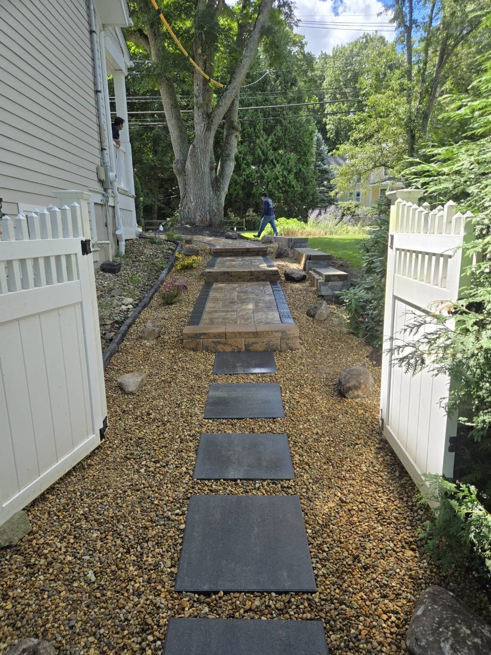 Sendero de piezas separadas a través del portón blanco en Needham, MA