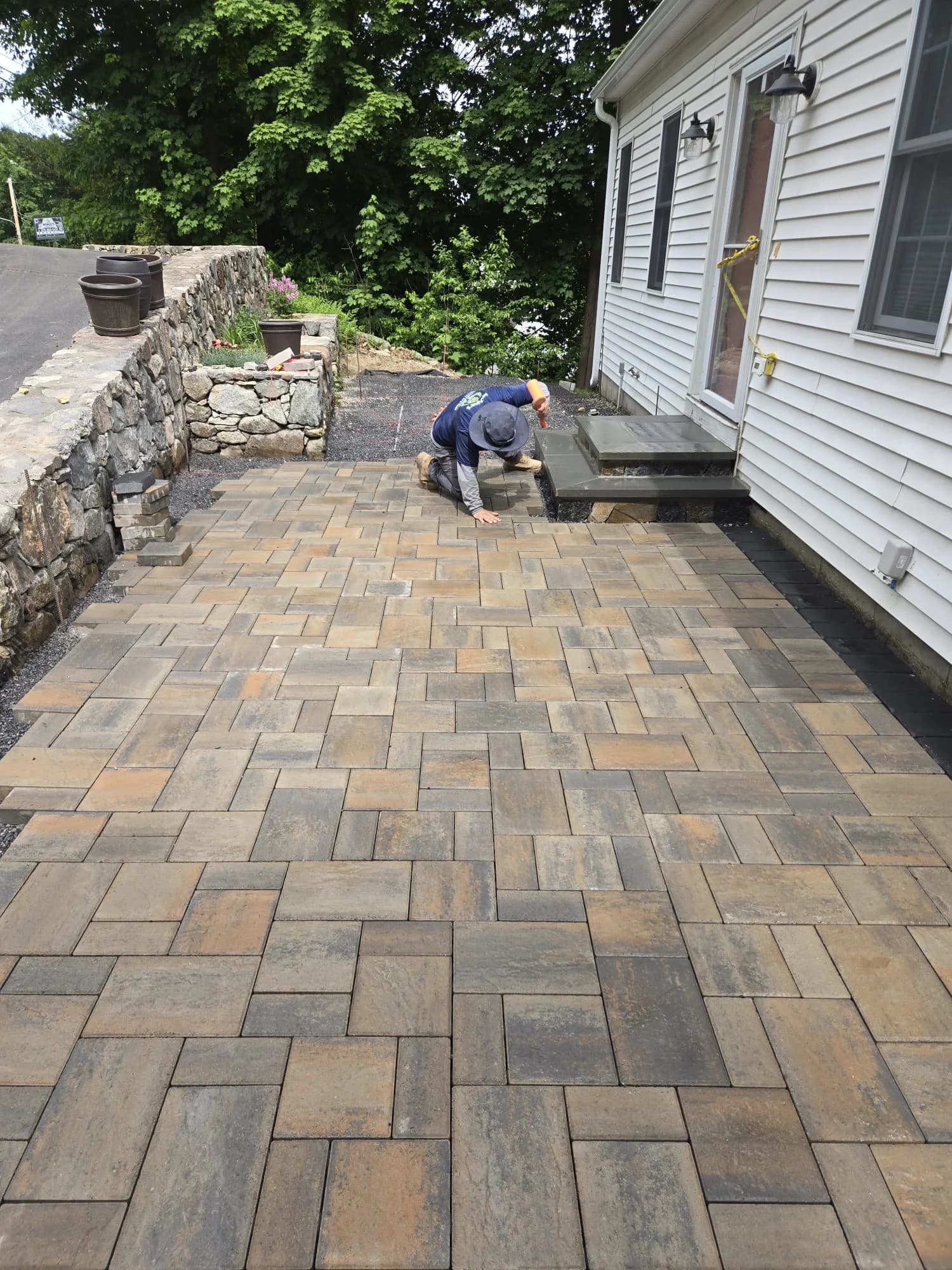 Patio pavers being installed beside the entrance in Hudson, MA