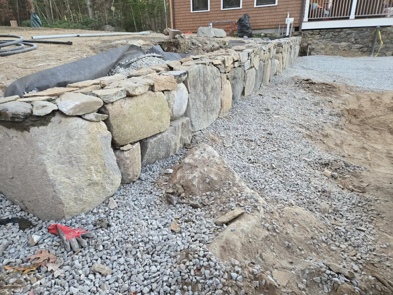 Natural stone retaining wall with gravel drainage base
